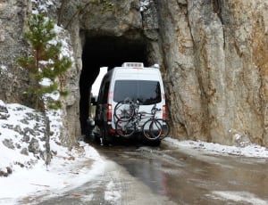 white van with bicycle on tail end approaching cave thumbnail