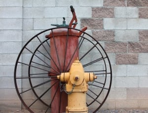 yellow fire hydrant with black and and red metal equipment thumbnail