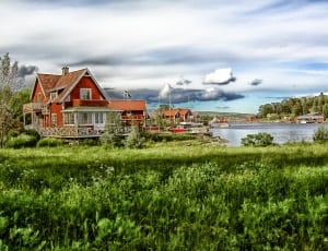 brown and white bungalow house along river thumbnail