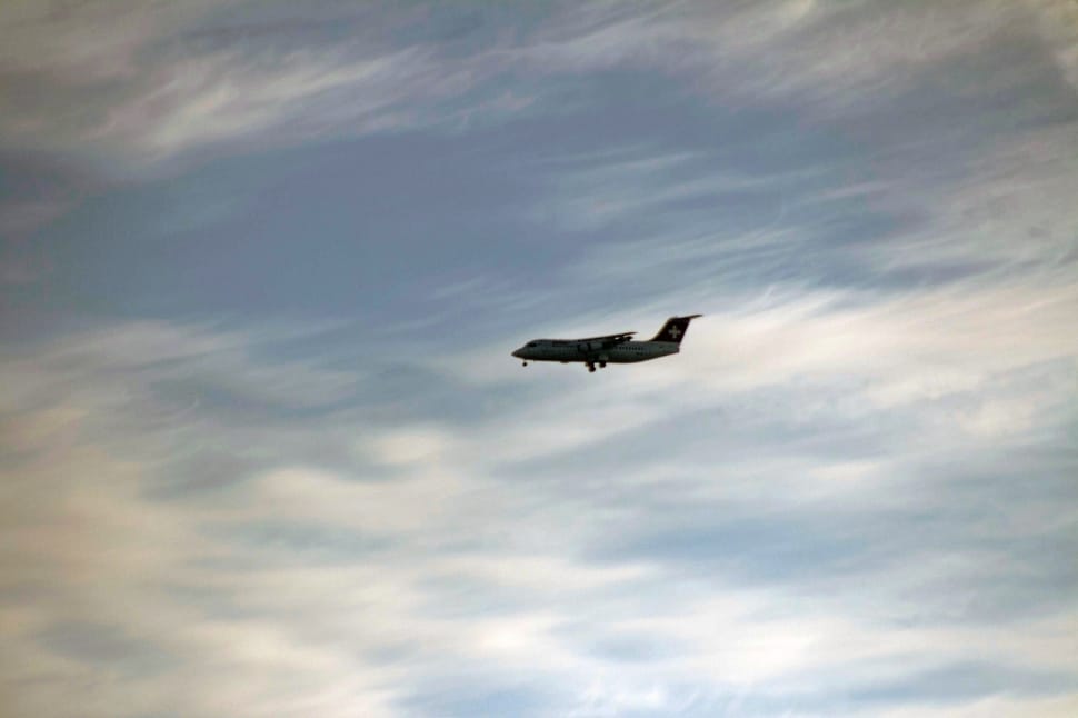 airplane under cloudy sky during daytime preview