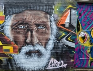 man in grey hat grafitti wall thumbnail