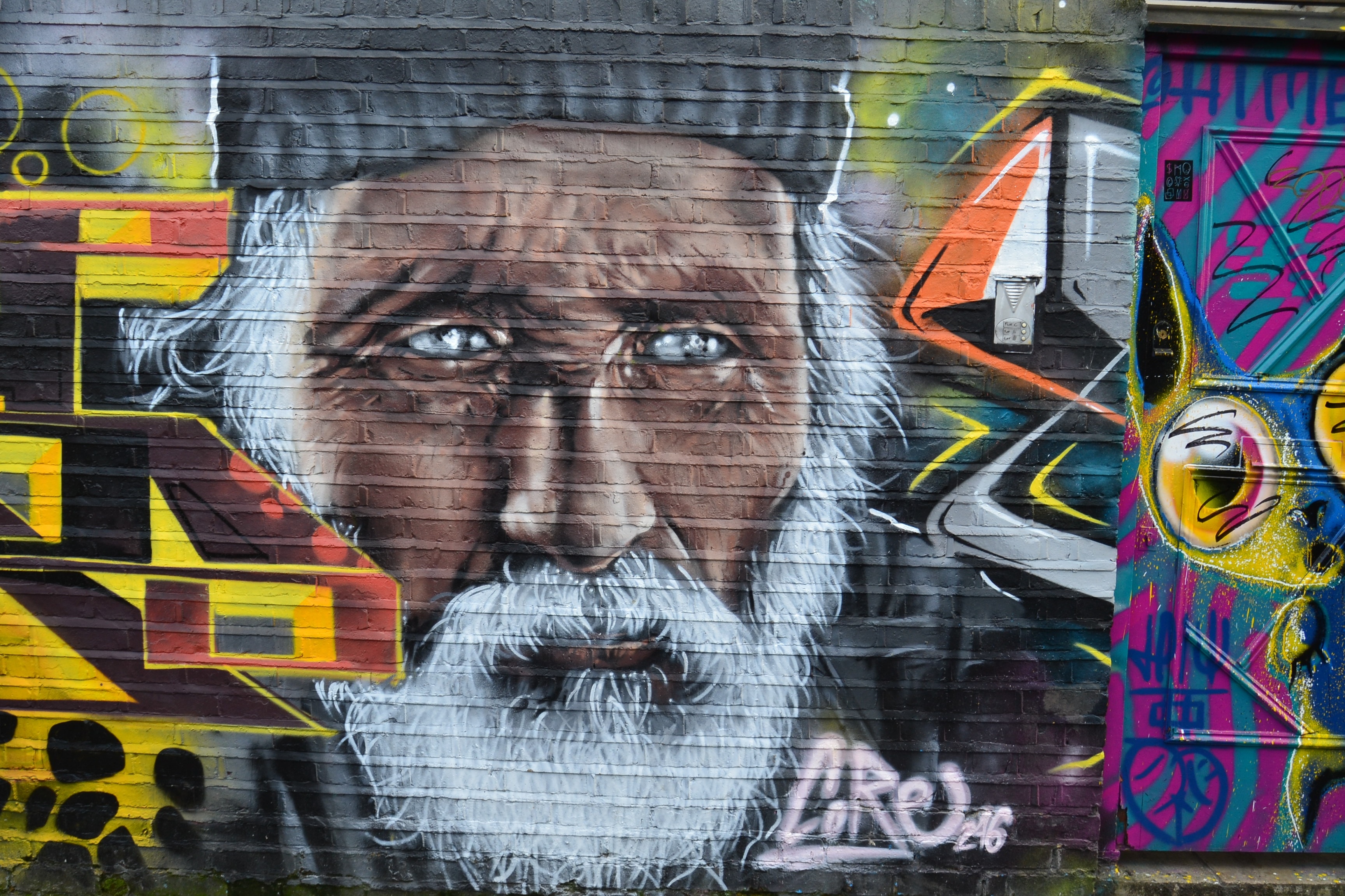 man in grey hat grafitti wall