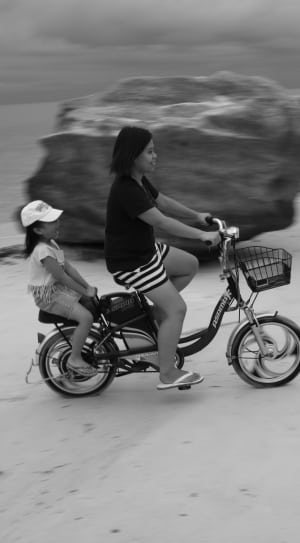 gray scale photo of 2 girls riding tandem bike thumbnail