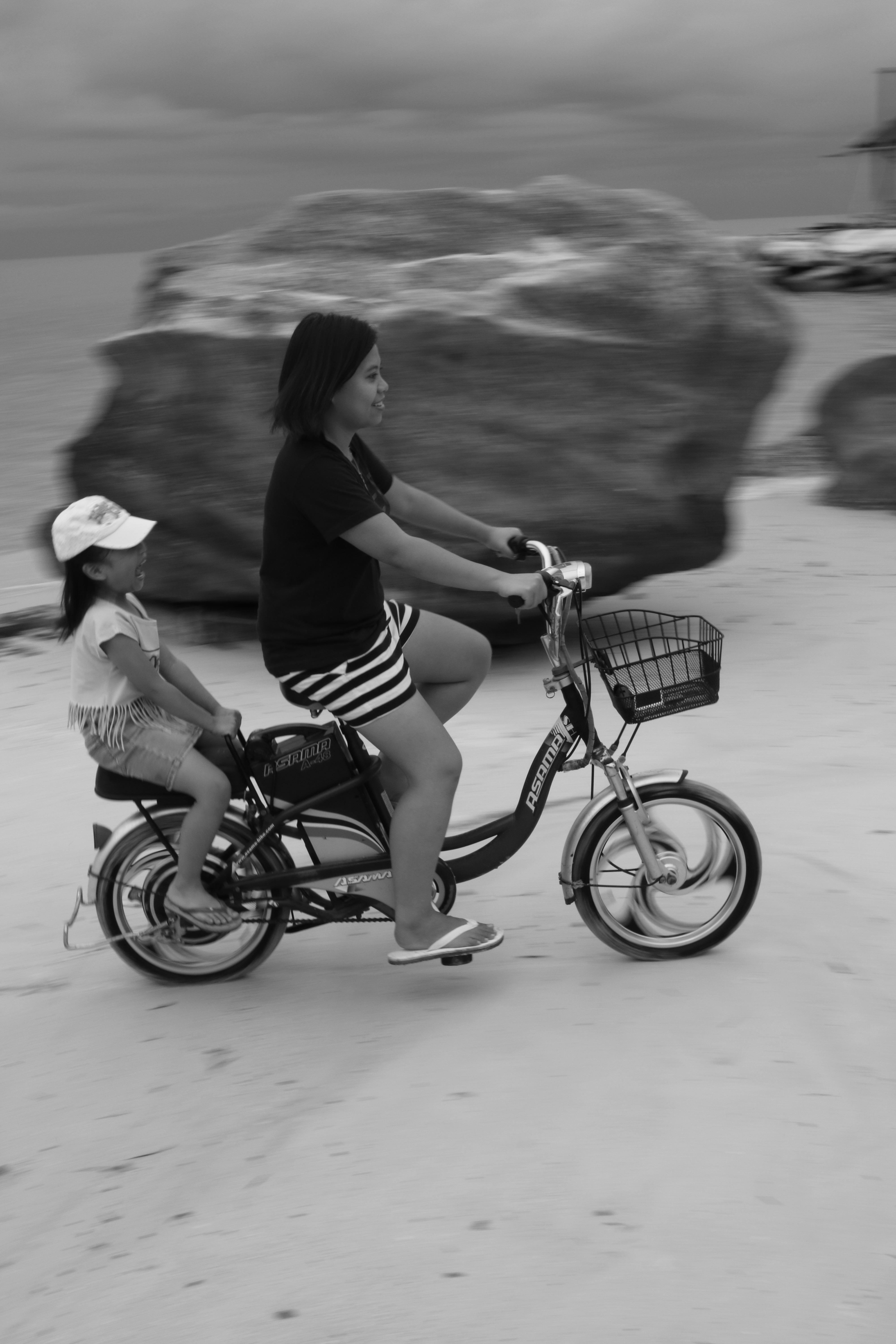 gray scale photo of 2 girls riding tandem bike