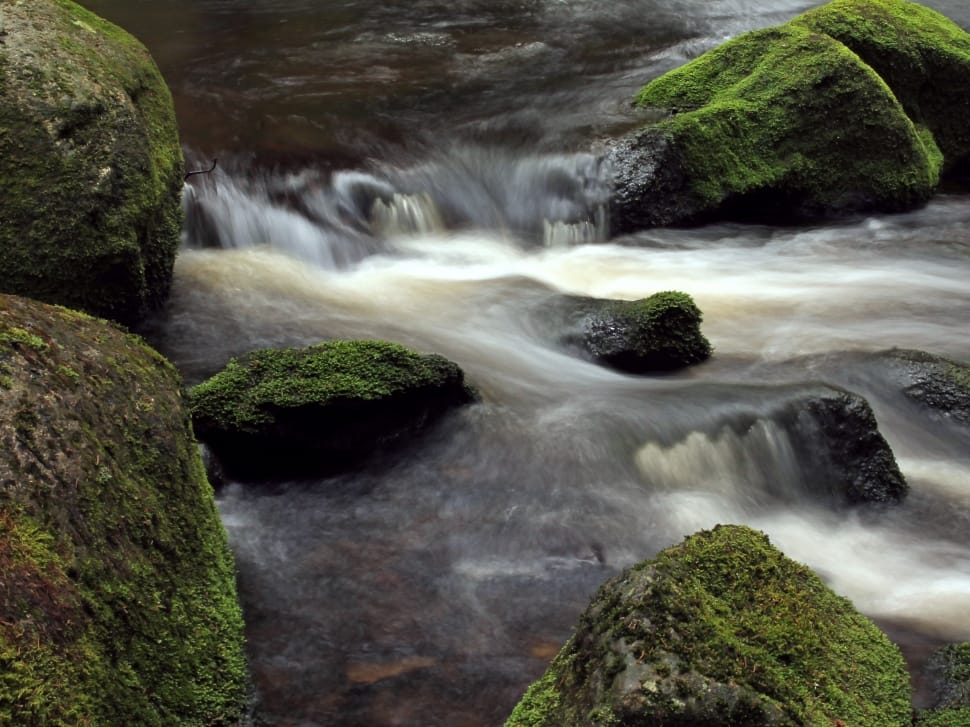 time lapse photography of waterfalls with black rocks and moss preview