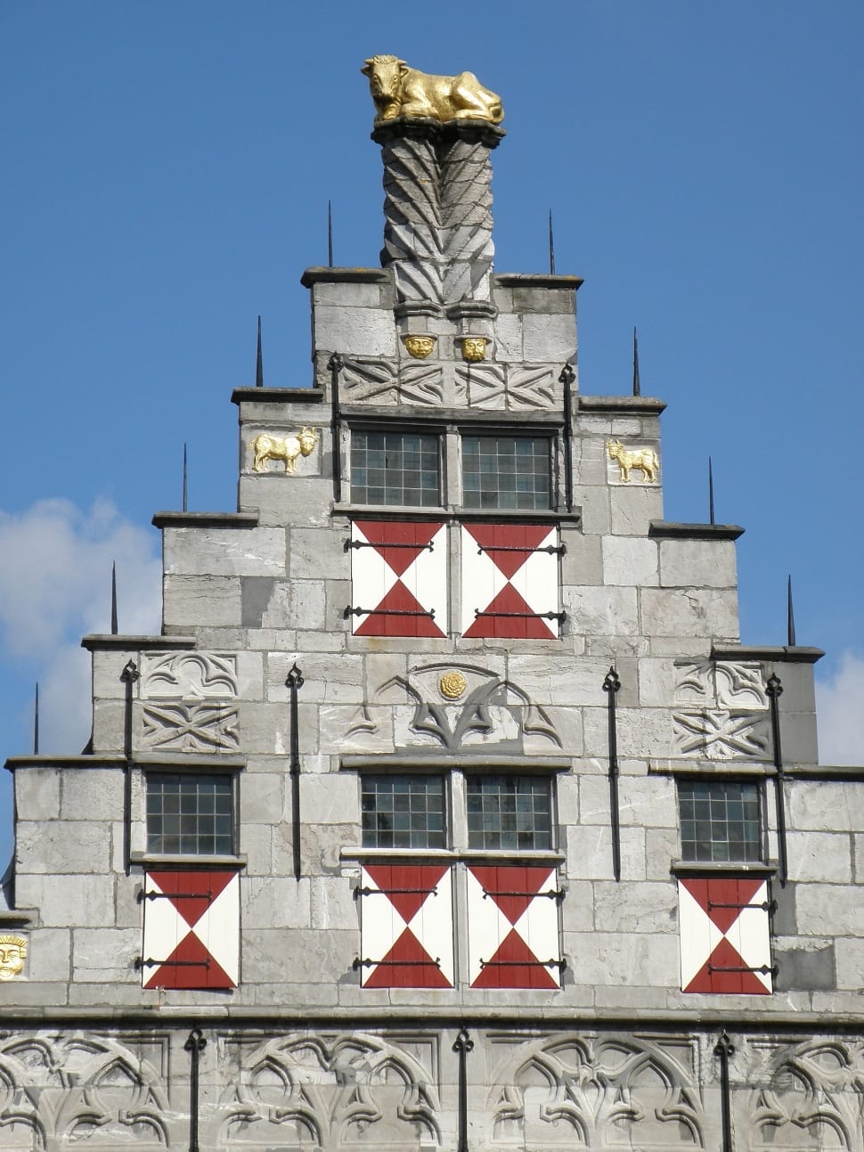 grey red and white concrete building with gold bull statue preview