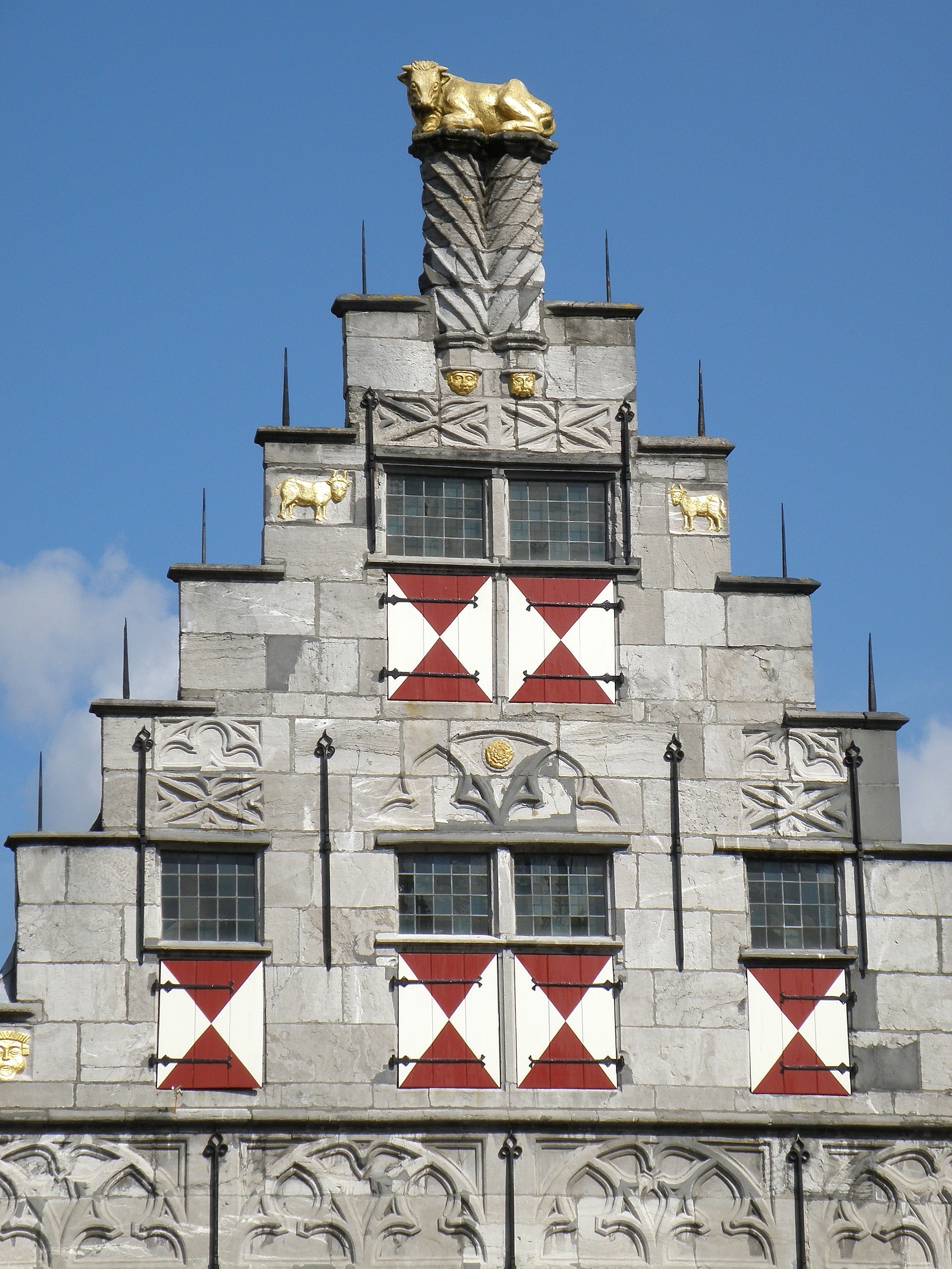 grey red and white concrete building with gold bull statue