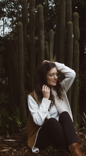 woman in white jacket near on cactus plant thumbnail