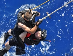 two man wearing wet suit holding on white rope during daytime thumbnail