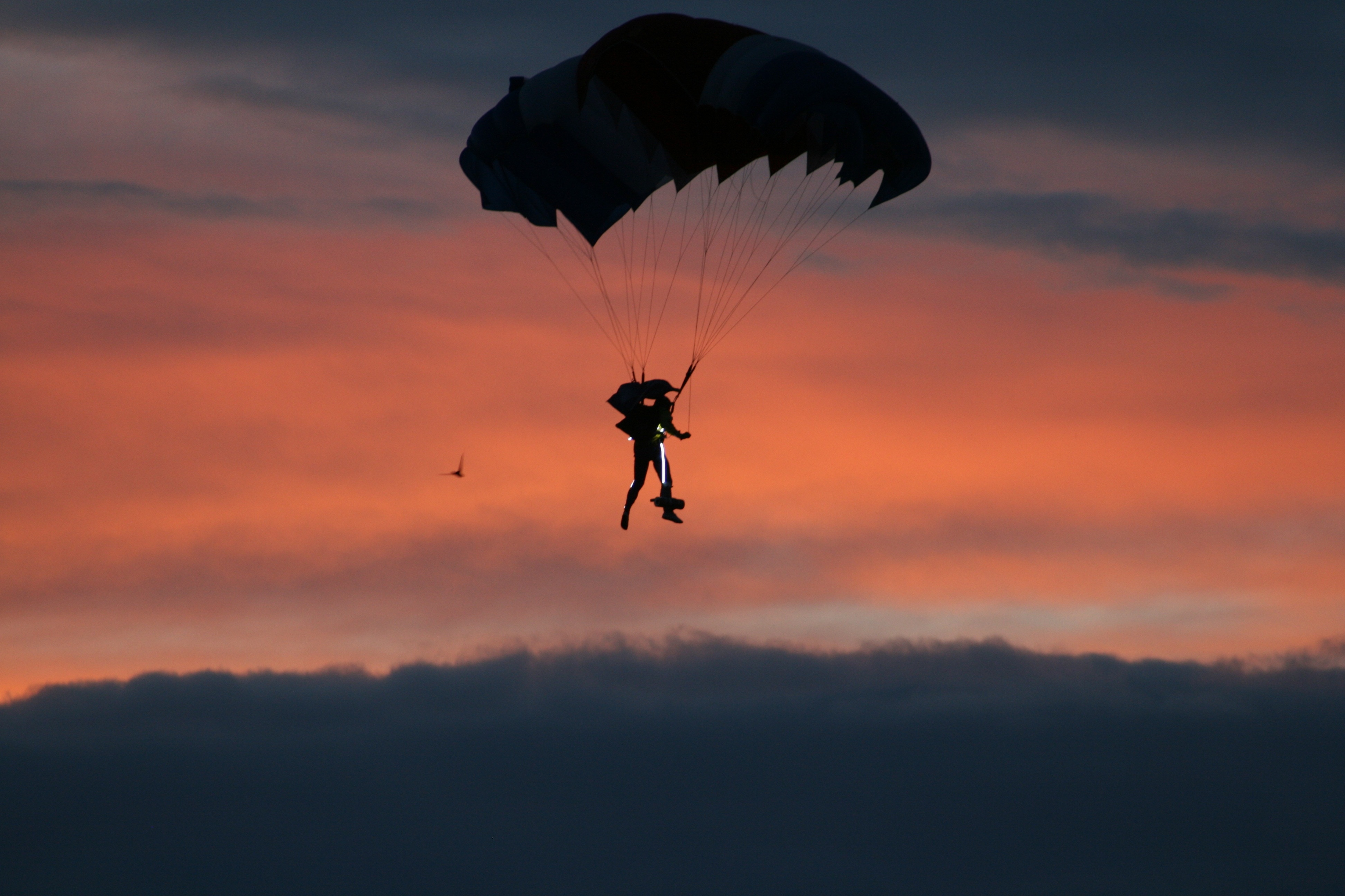 silhouette of person paragliding