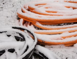 orange plastic tube covered with snow thumbnail