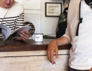 person in white and black stripe long sleeve shirt holding a book thumbnail