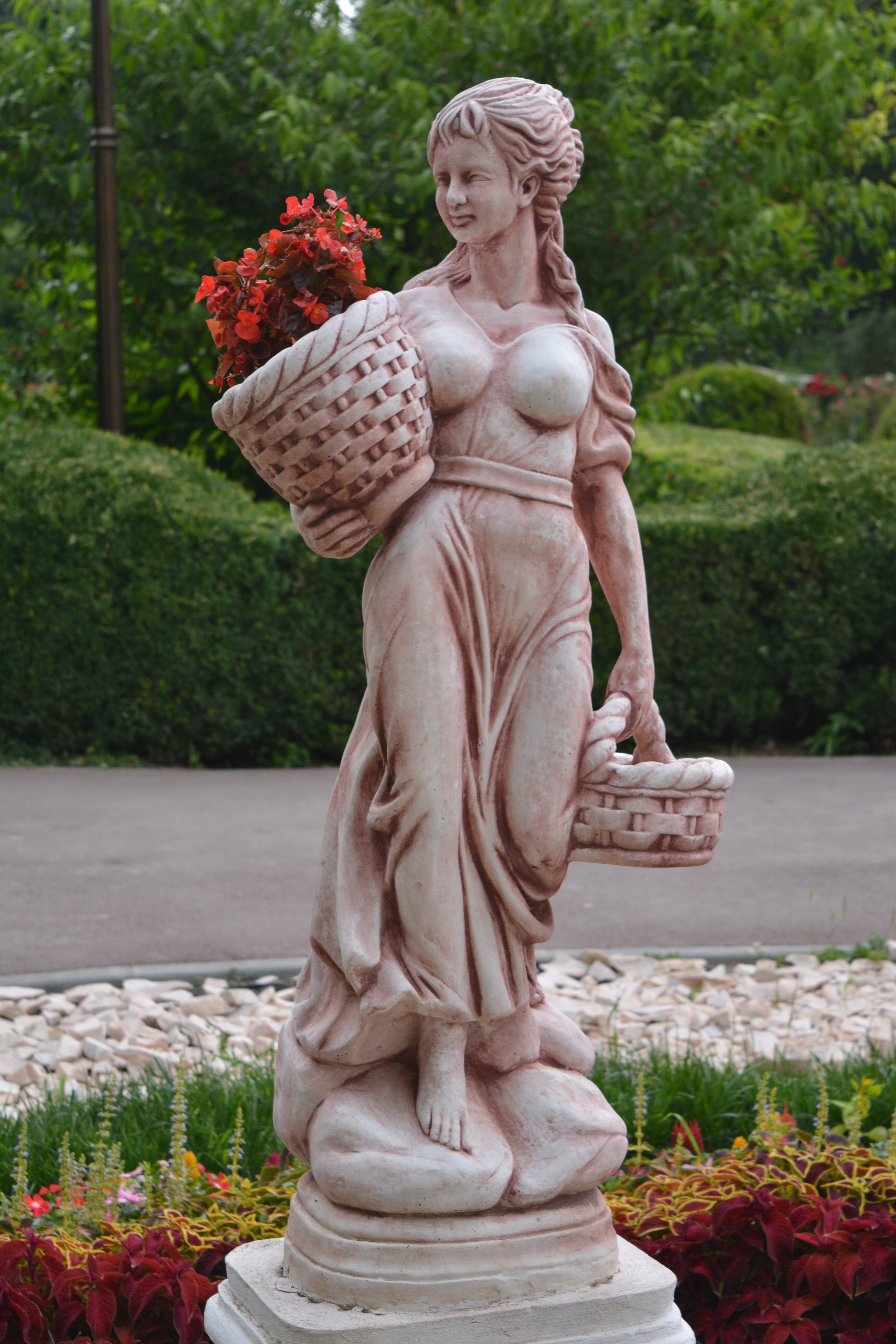 woman in white suit holding basket statue.