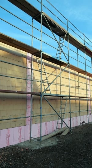 scaffolding beside yellow brick wall thumbnail