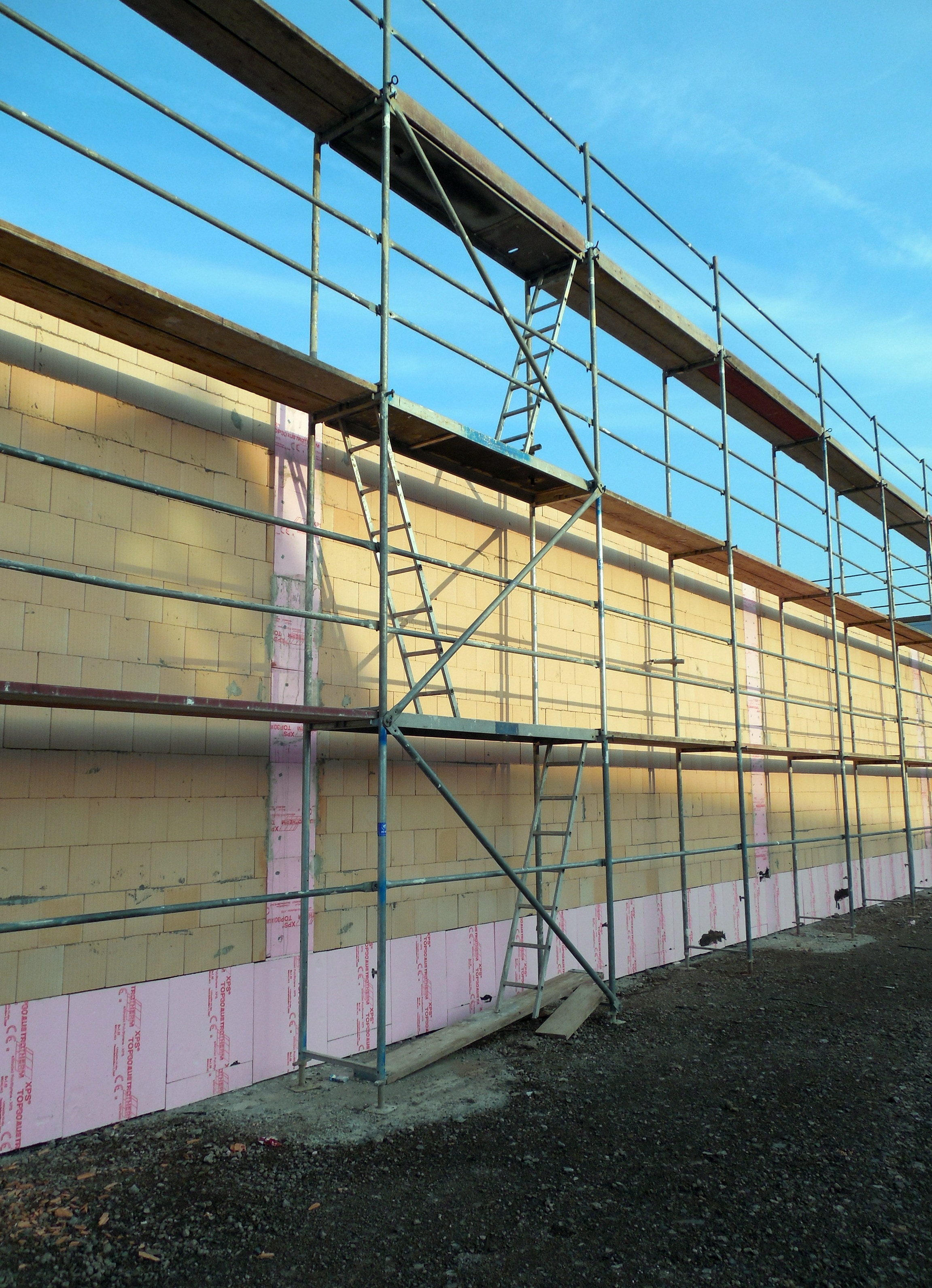 scaffolding beside yellow brick wall