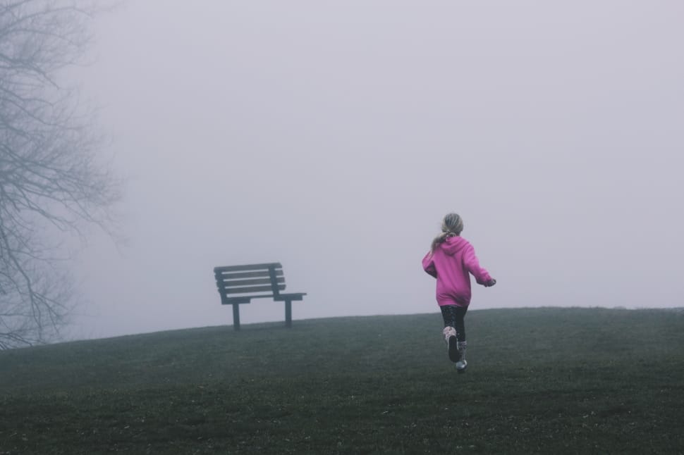 female wearing pink jacket running toward green grass preview