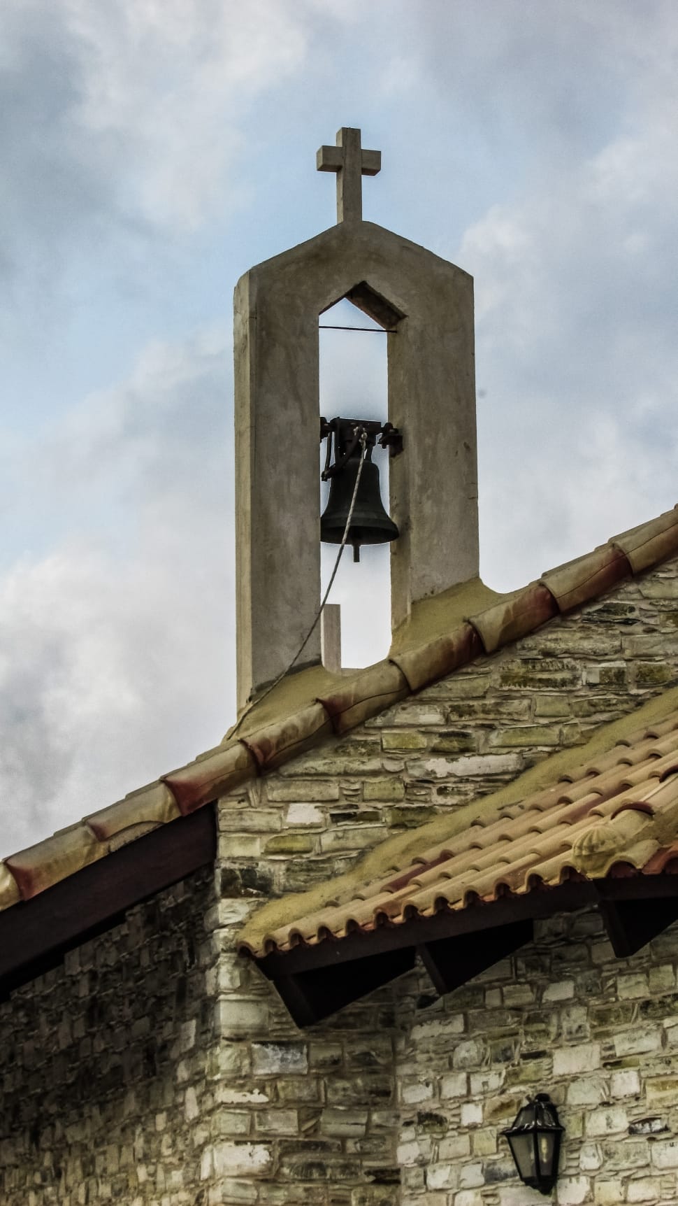 church bell under cloudy sky during daytime preview