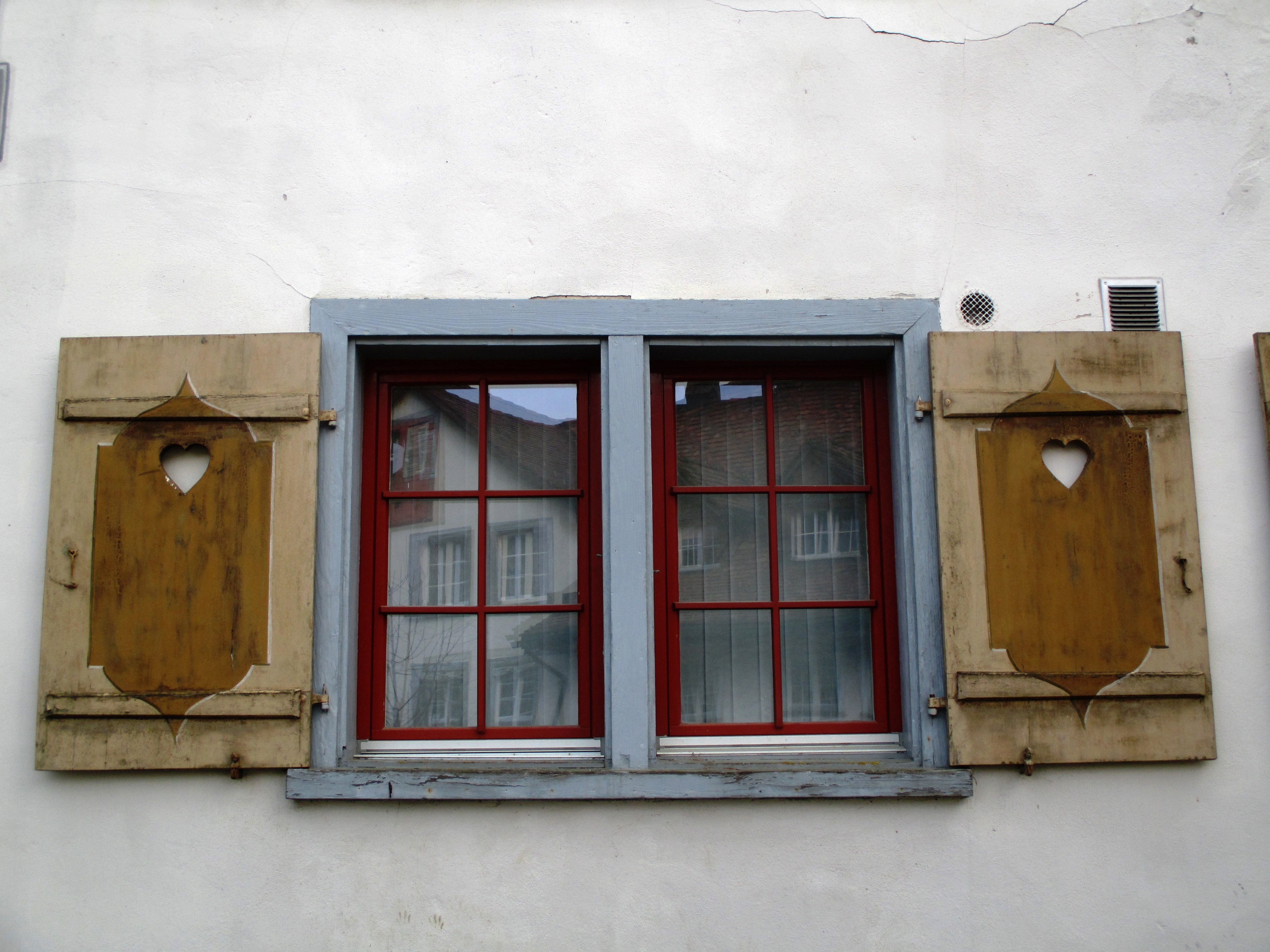 gray brown and red wooden window with shutter decor