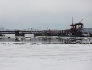 architectural shot of bridge on snowy body of water thumbnail