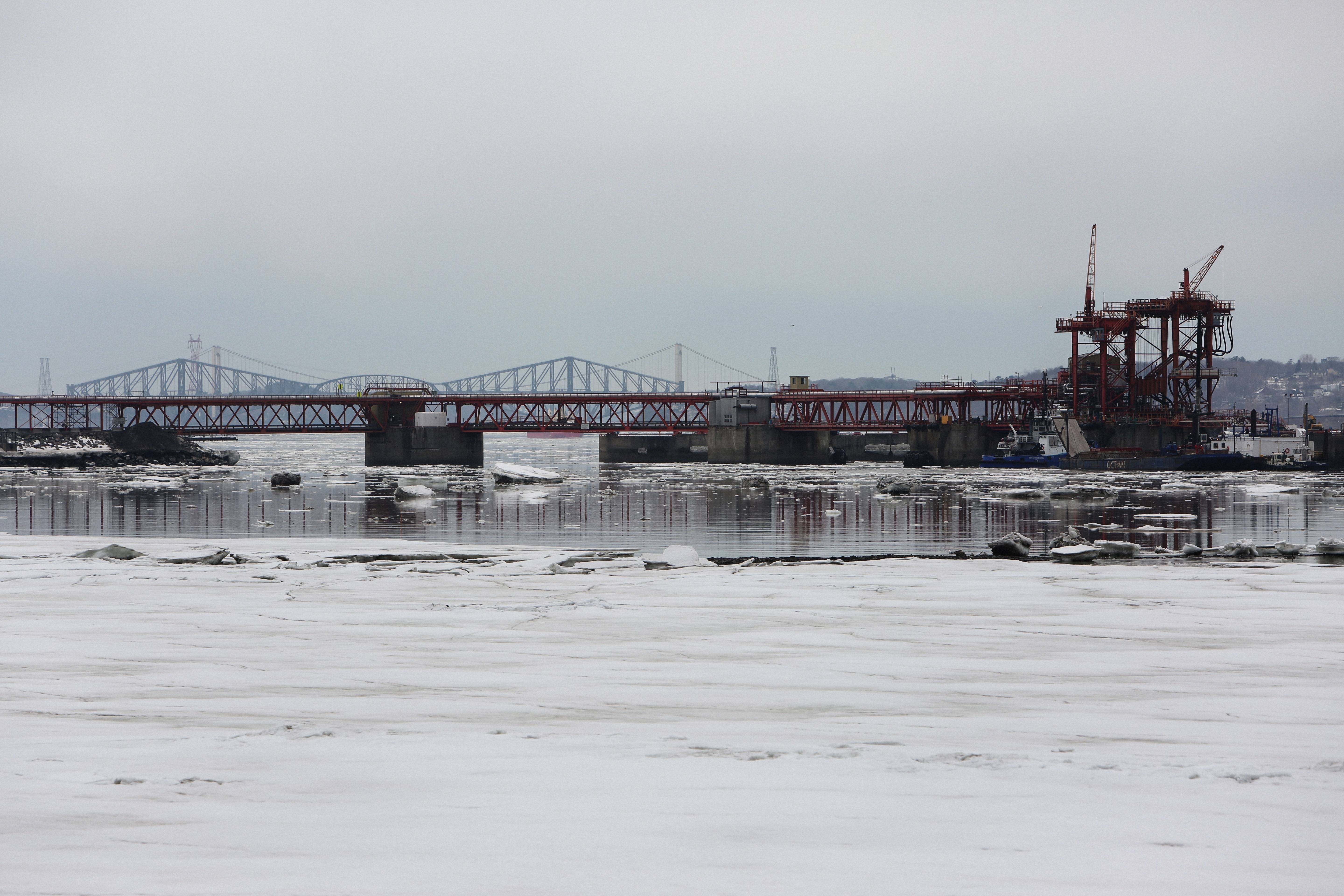 architectural shot of bridge on snowy body of water