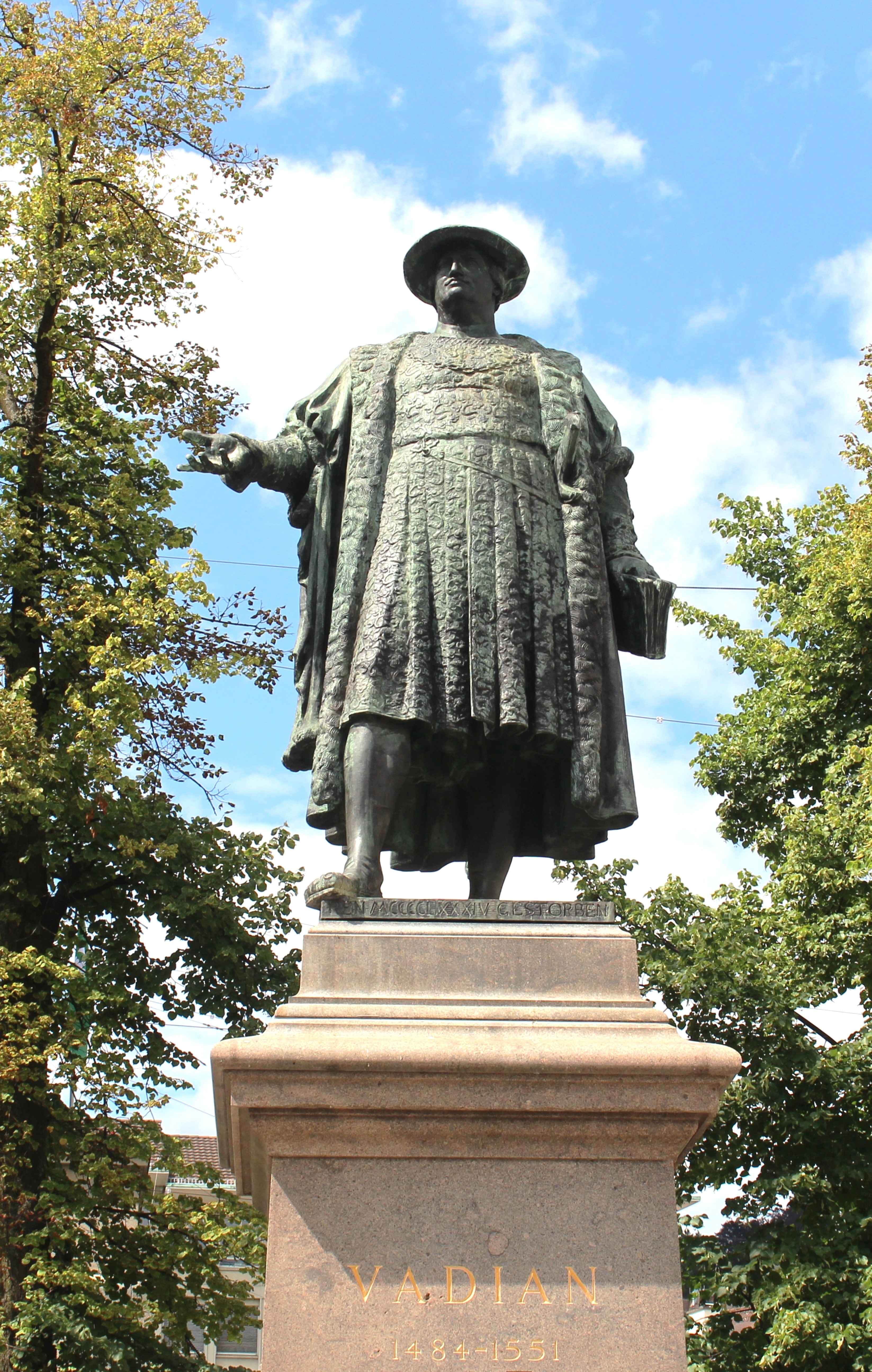 man in round hat and coat concrete statue