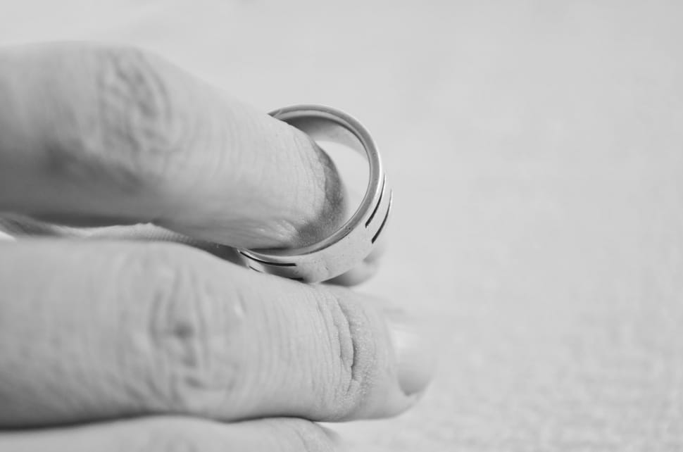greyscale photo of hand holding ring preview