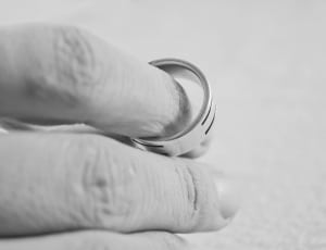 greyscale photo of hand holding ring thumbnail