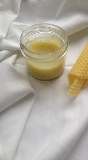 clear glass jar with paste beside cone on top of white textile thumbnail