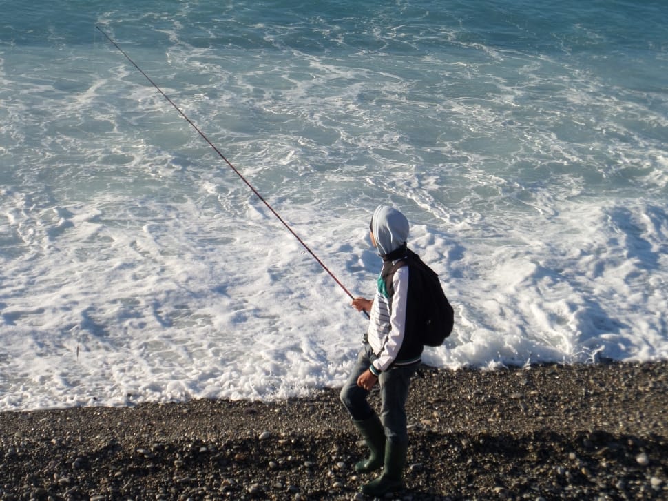 man wearing gray pull over hoodie holding a fishing rod preview