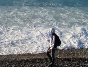 man wearing gray pull over hoodie holding a fishing rod thumbnail