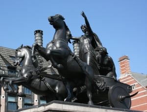 man next to carriage and horse statue thumbnail