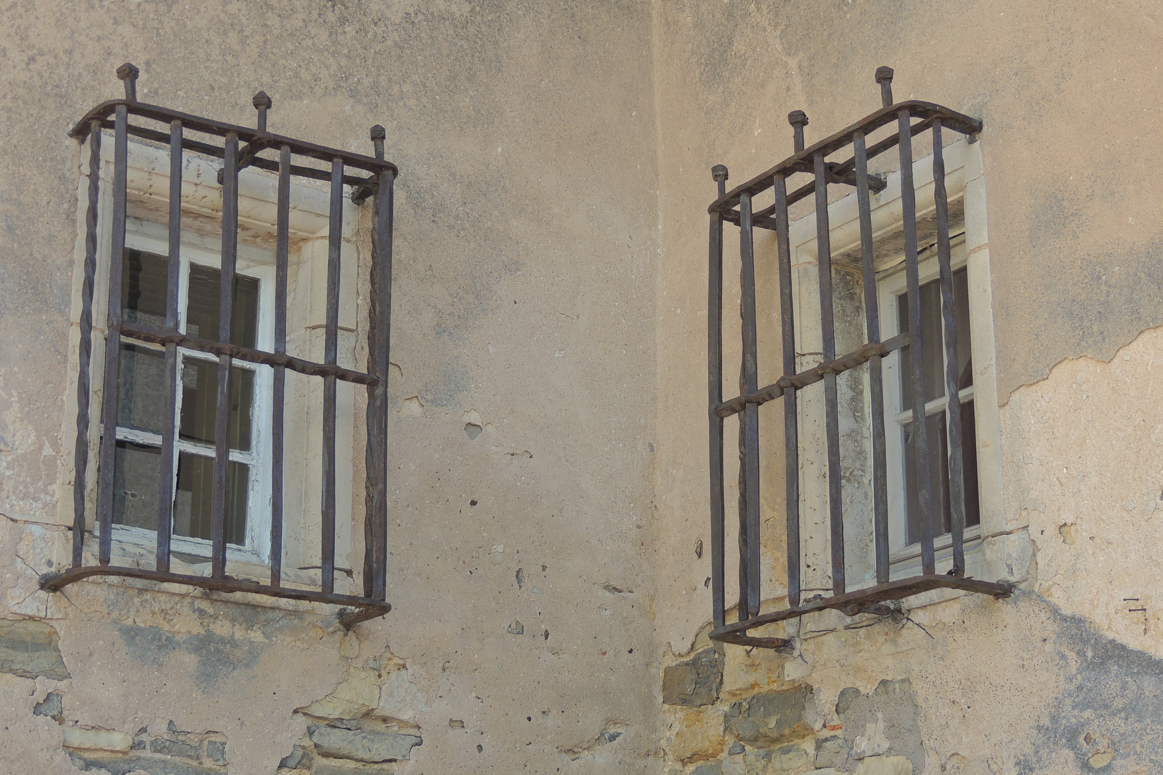 two windows with black metal grills