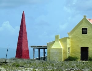 yellow concrete house beside red tower thumbnail