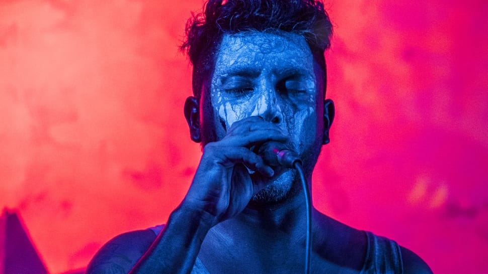 man in blue body paint holding microphone preview