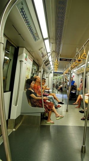person sitting and standing in train thumbnail