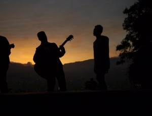 3 man playing musical instruments during sunset picture thumbnail