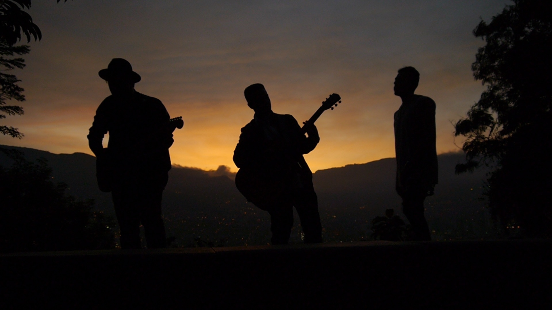 3 man playing musical instruments during sunset picture