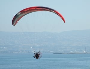 person paragliding under blue sky during daytime thumbnail