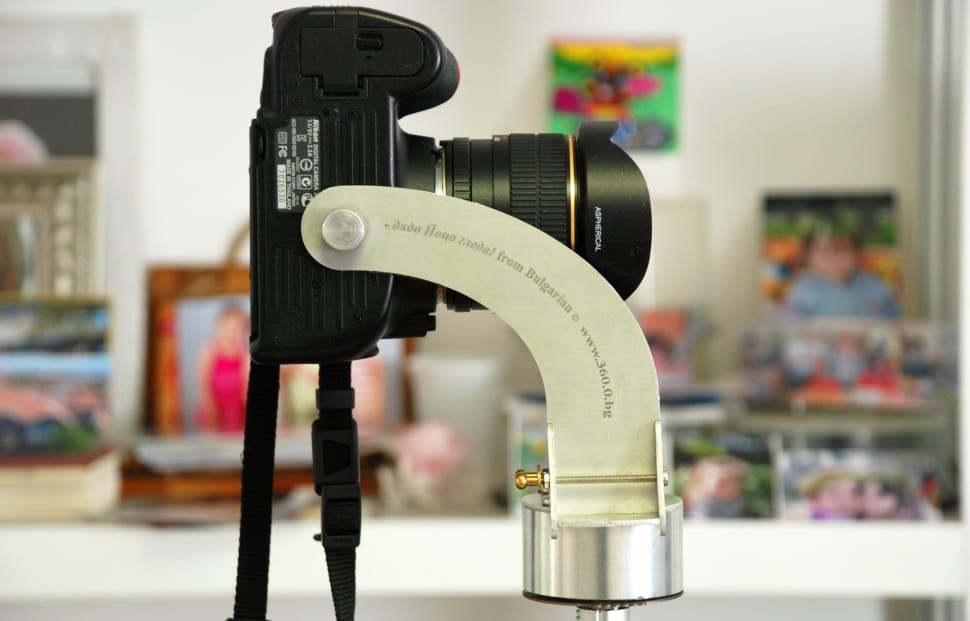 selective focus photography of black dslr camera on gray camera holder preview