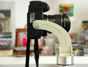 selective focus photography of black dslr camera on gray camera holder thumbnail