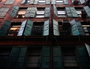 brown and gray concrete building with open windows thumbnail