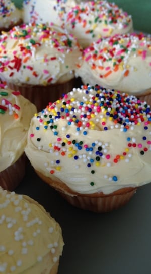 cupcakes topped with white cream and sprinkles thumbnail