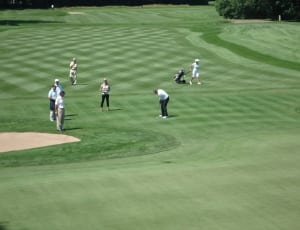 aerial photography of people playing golf on green grass field during daytime thumbnail