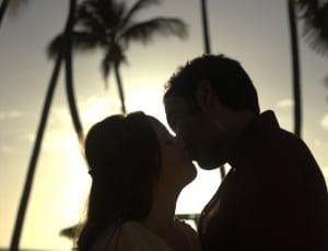 Silhouette photography of couple during golden hour with coconut trees background thumbnail
