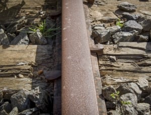 brown steel railway surrounded with rocks thumbnail