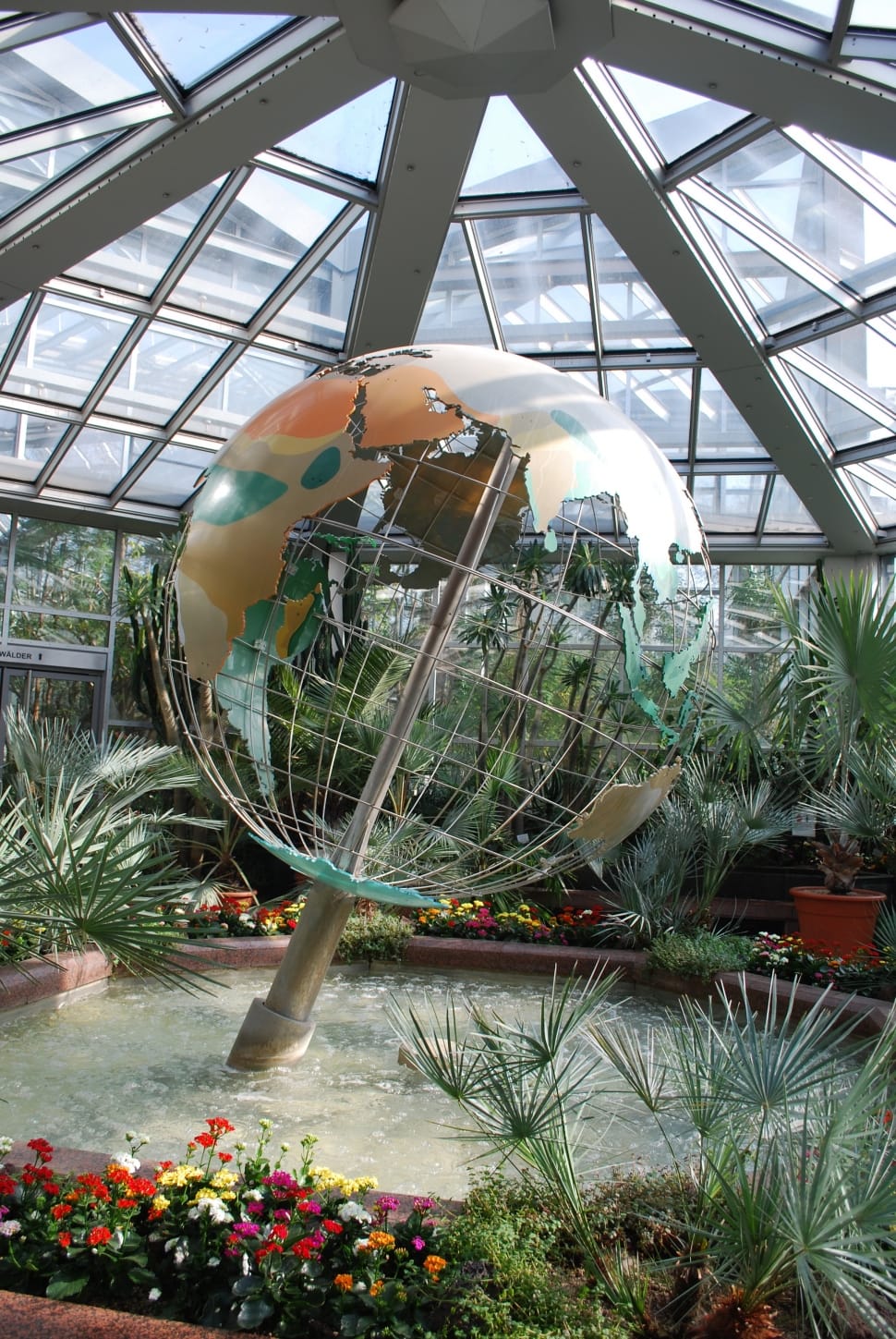 stainless steel, green and beige mesh globe on body of water near green leaf plants preview