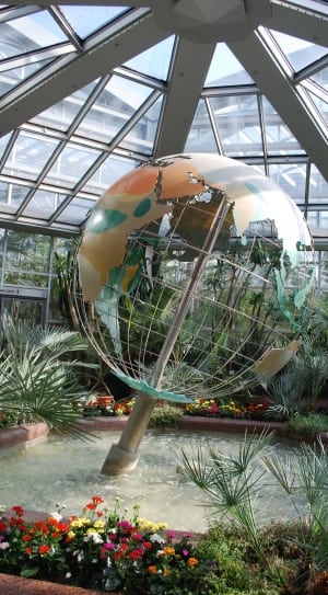 stainless steel, green and beige mesh globe on body of water near green leaf plants thumbnail