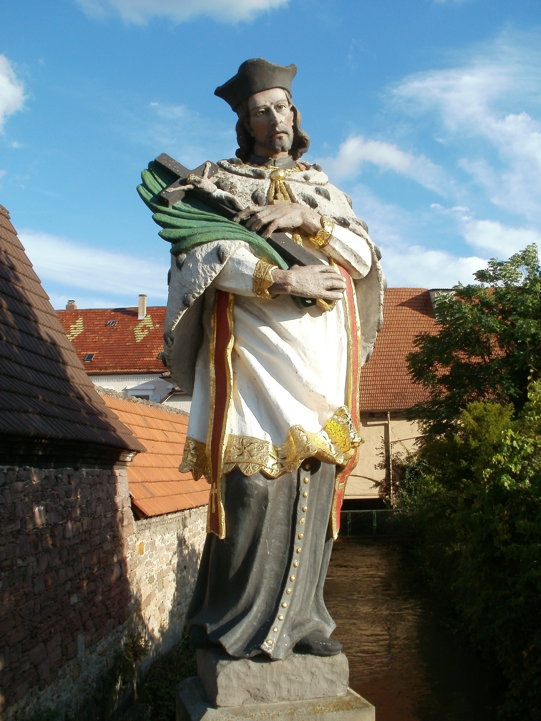 man holding crucifix statue