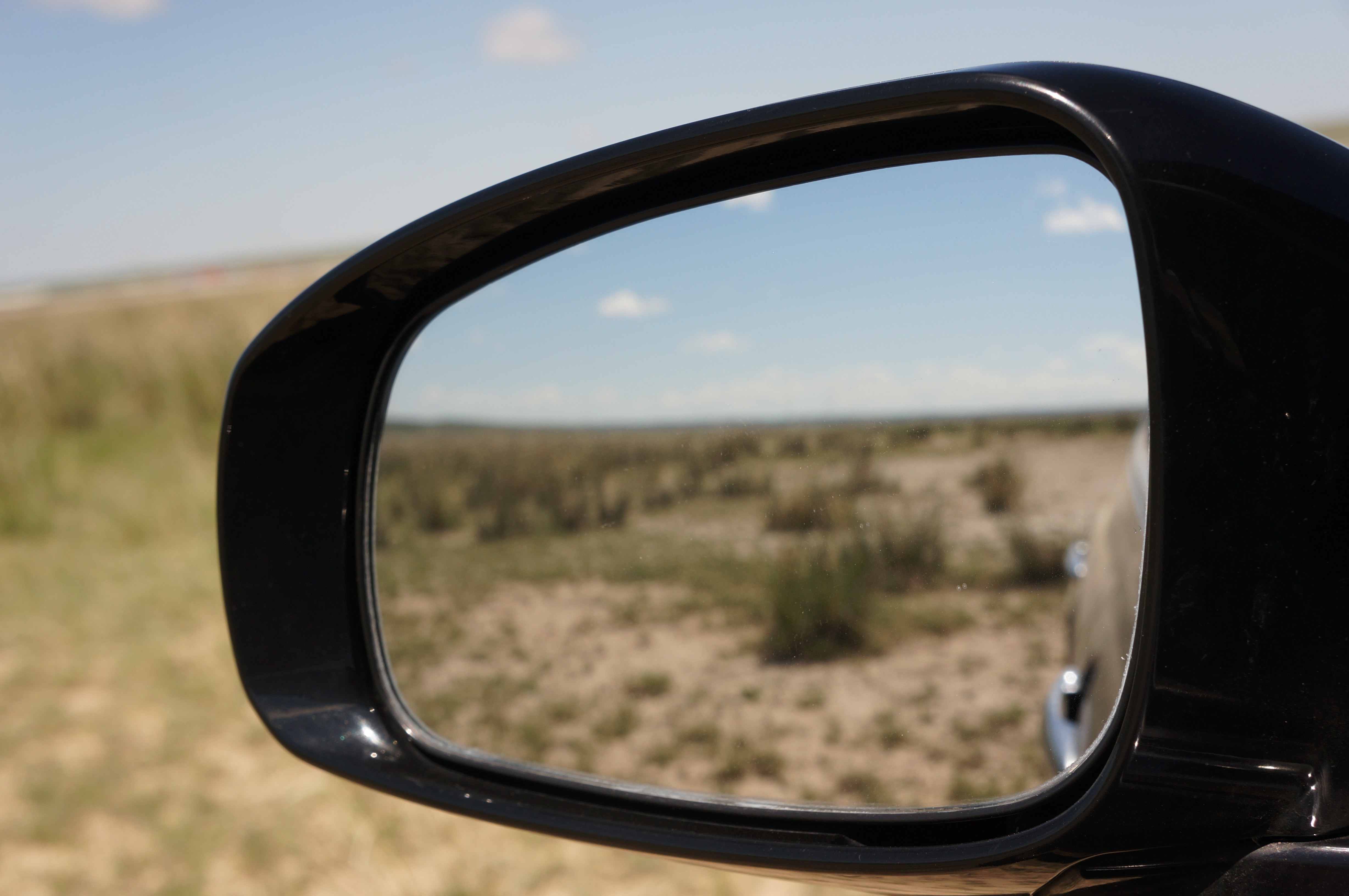 black car side mirror on desert