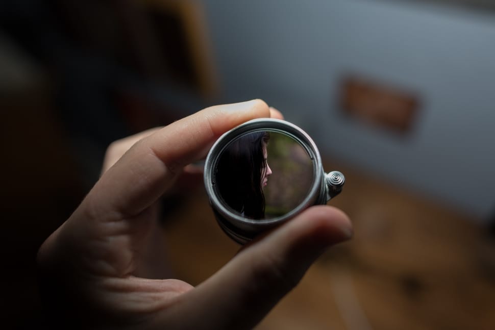 shallow focus photography of silver round device showing woman preview
